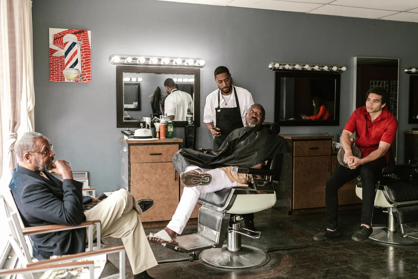 Customers seated in a neighborhood barbershop