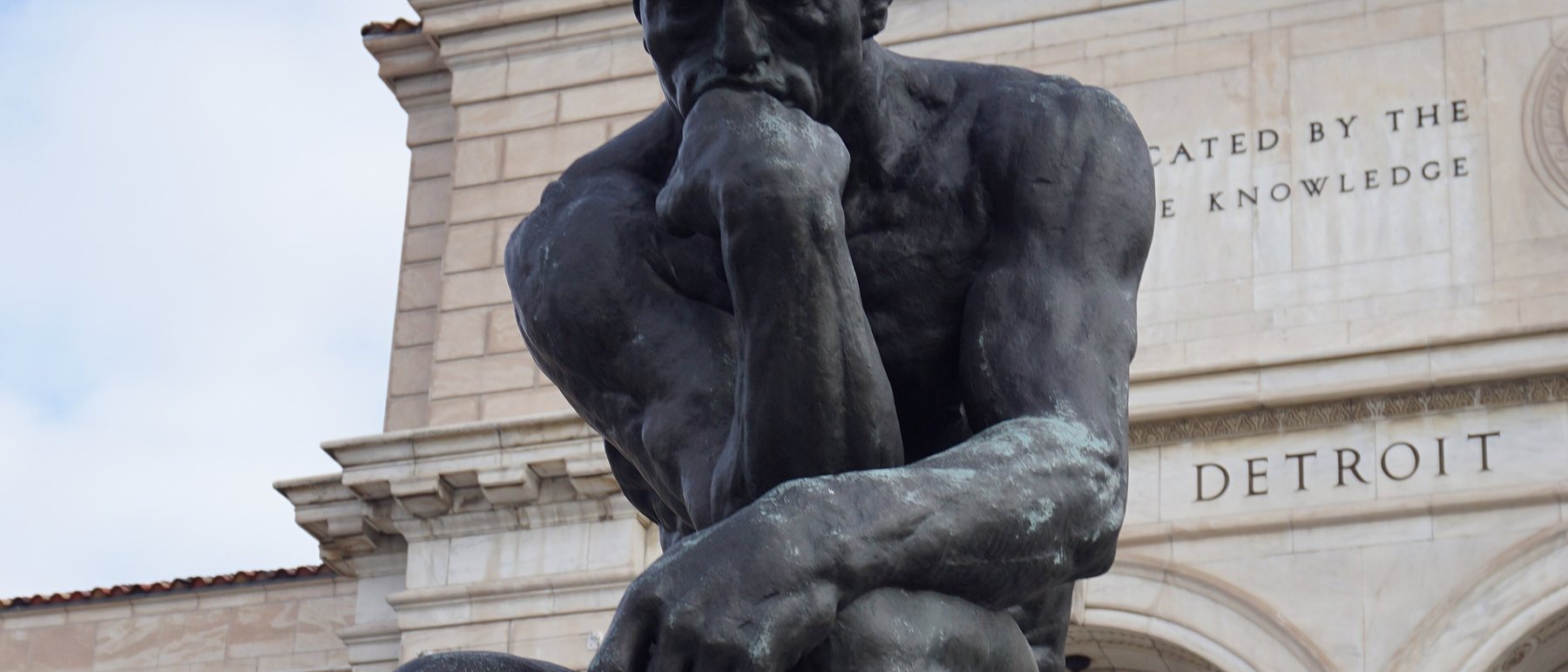 Rodin's Thinker in front of the Detroit Institute of Arts, the words DEDICATED
BY THE PEOPLE and DETROIT carved in the marble behind