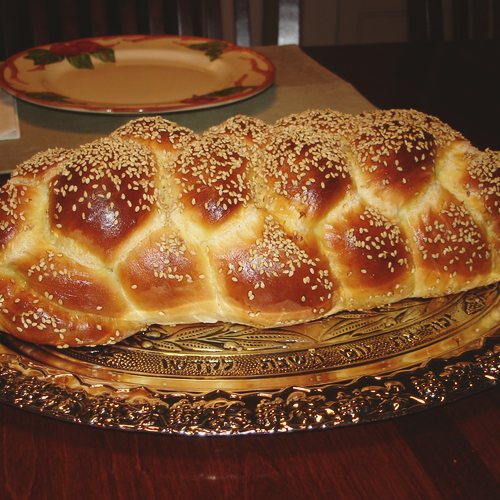 A braided challah loaf on a plate.