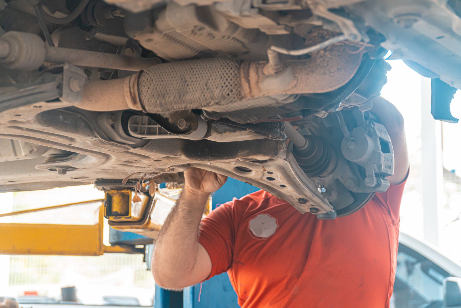The underside of a raised vehicle showing exhaust and suspension components.