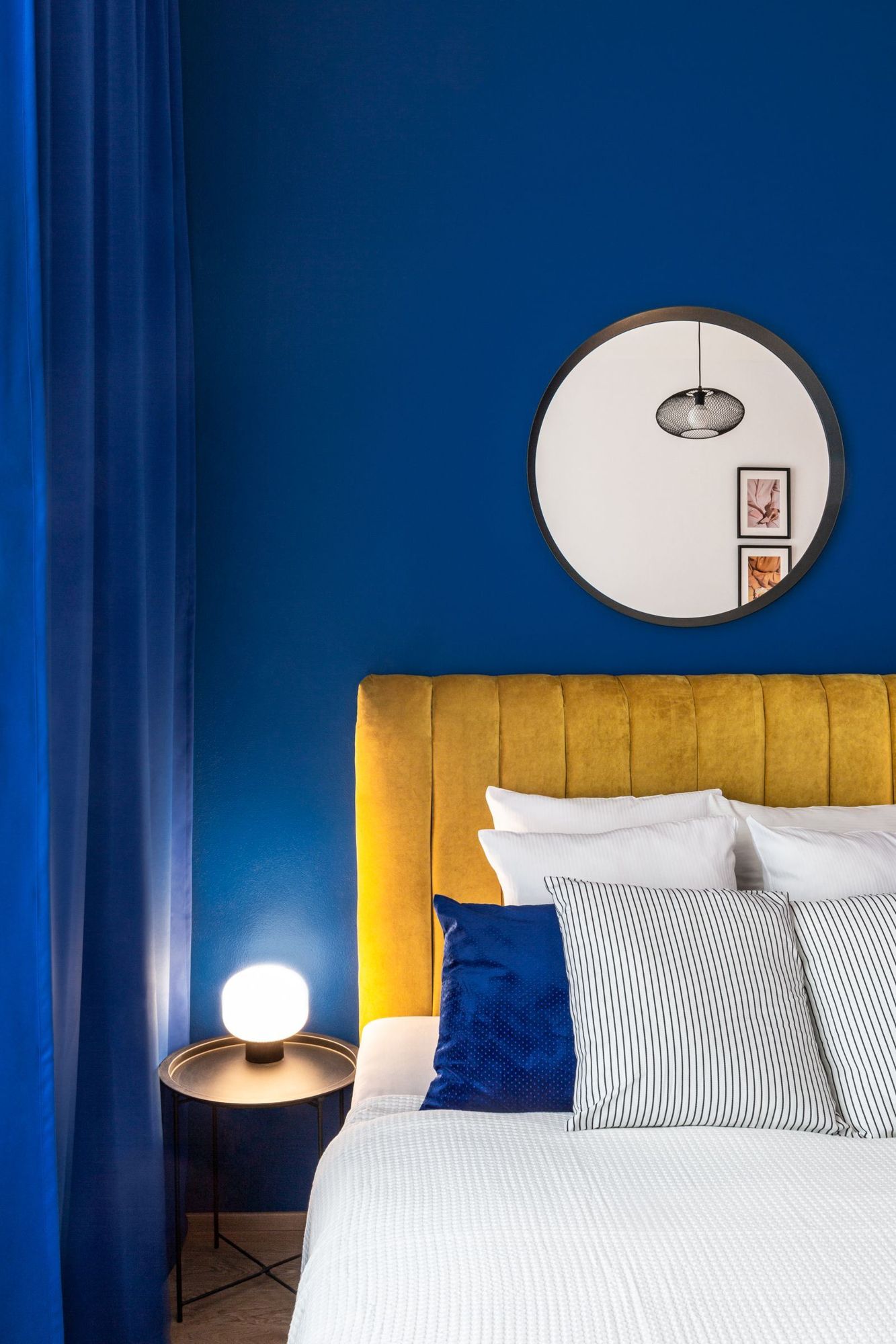 Blue wall beside a mustard upholstered headboard