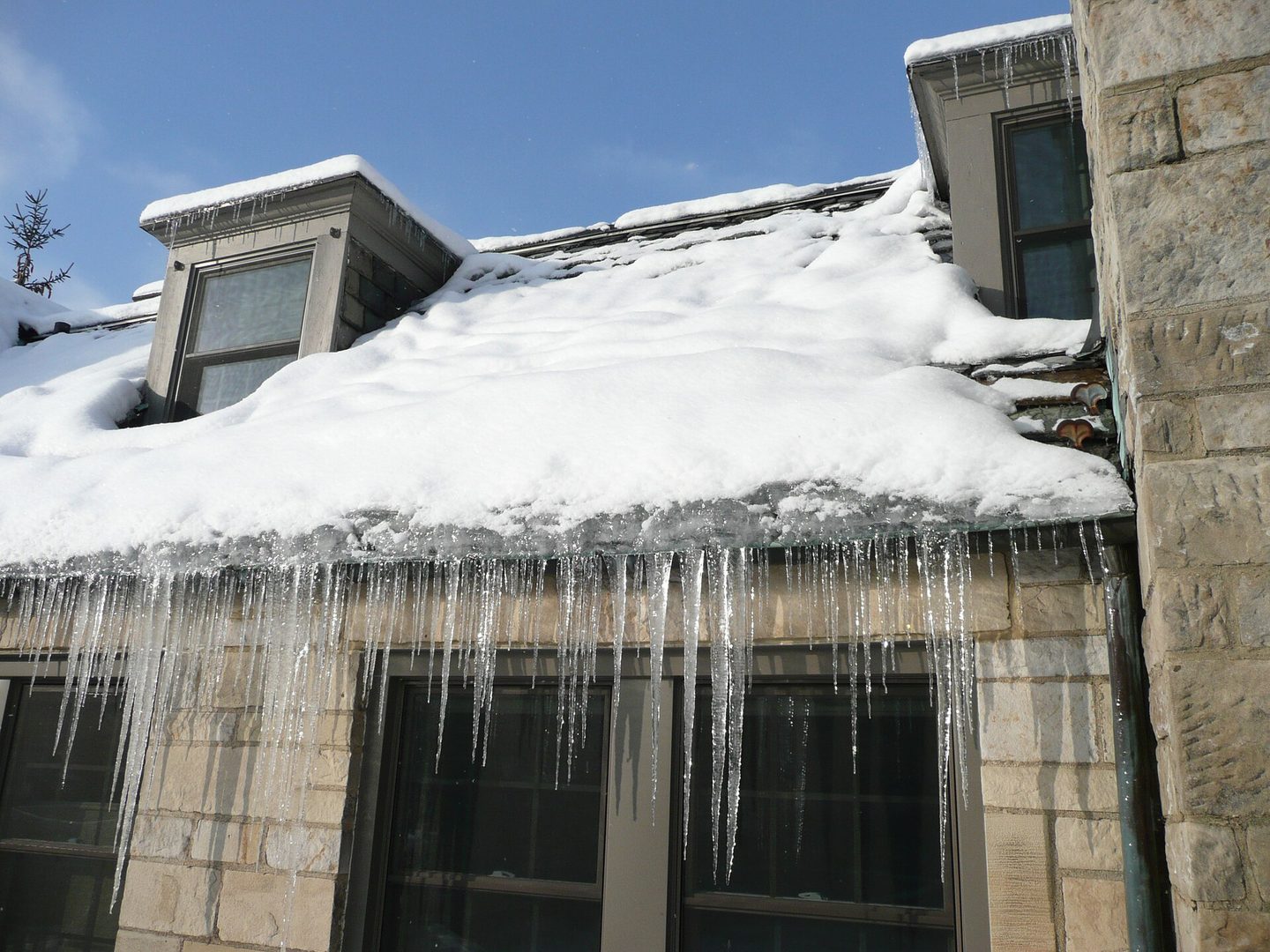 Ice buildup and icicles along a snow-covered roof