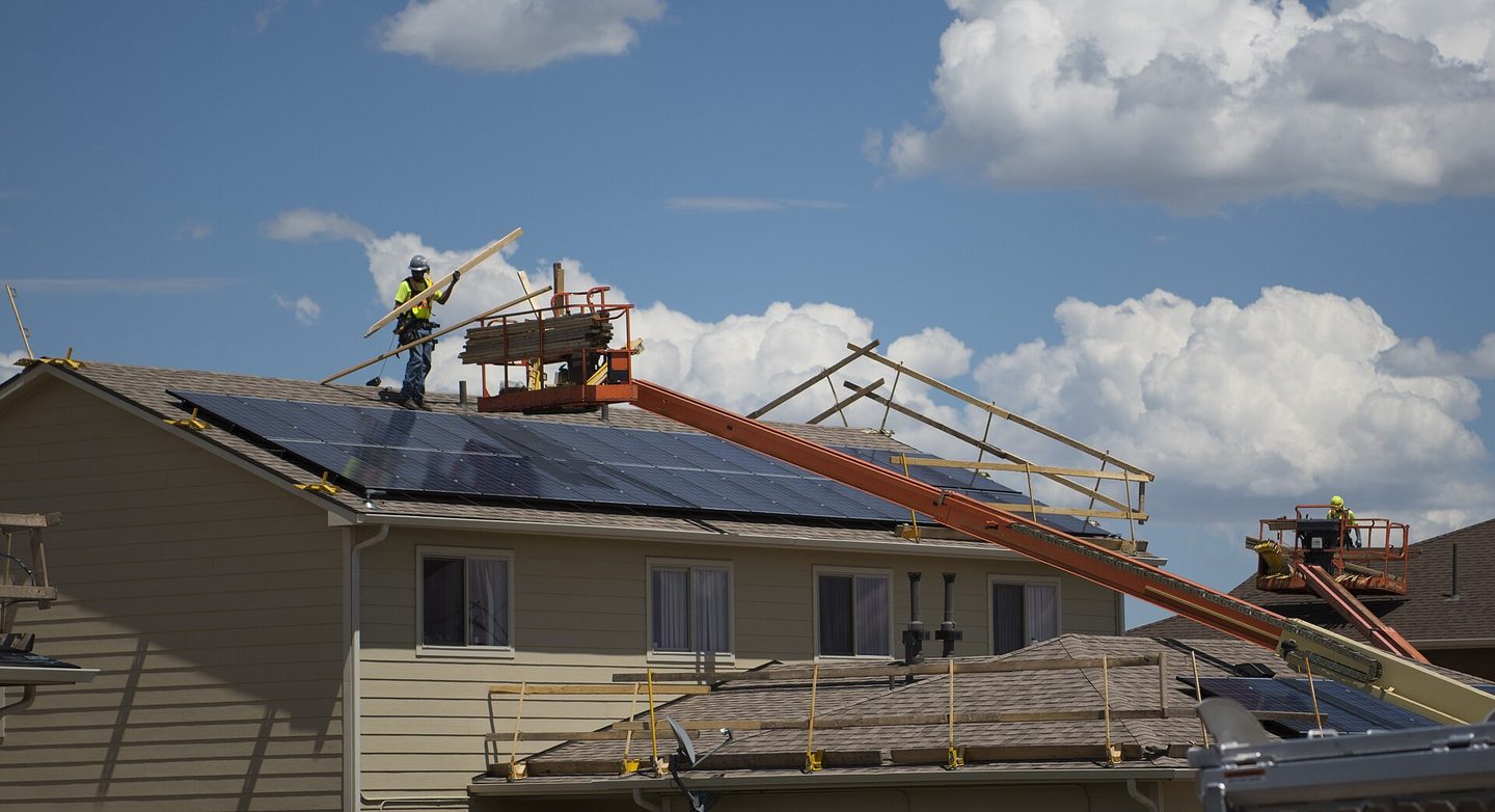 House with roofing staging and a conveyor extending to the eave