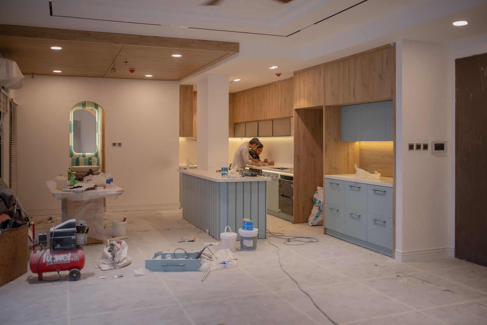 Two tradespeople working together in a room under construction.