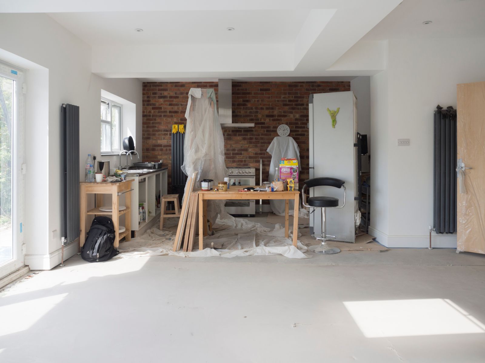 A stripped room with tools and protective sheeting during the works.