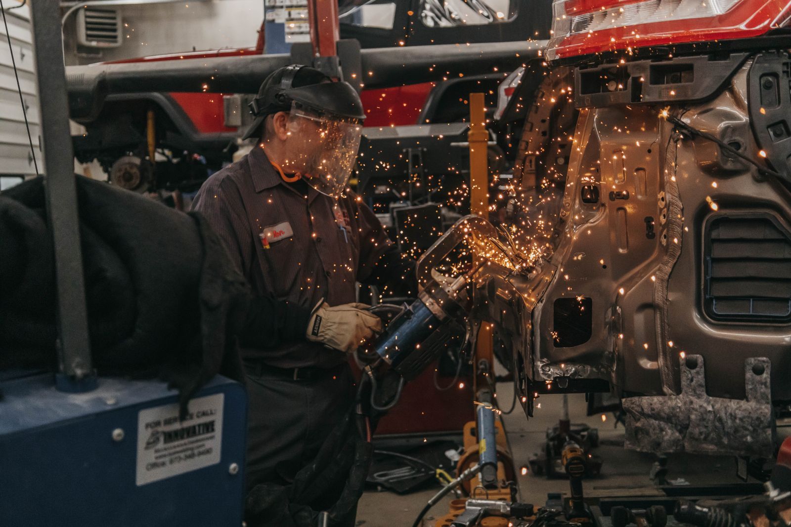 A technician welding a stripped vehicle body