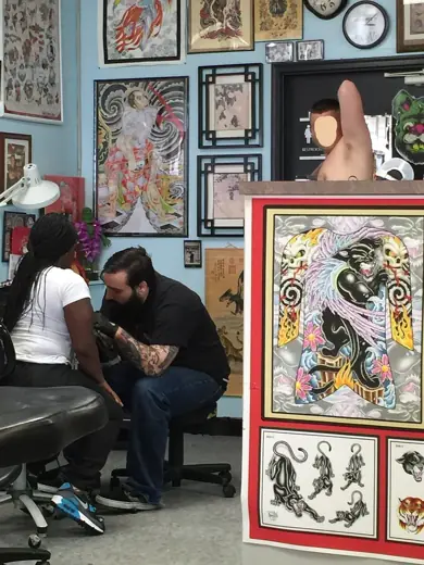 An artist working under a wall of framed flash