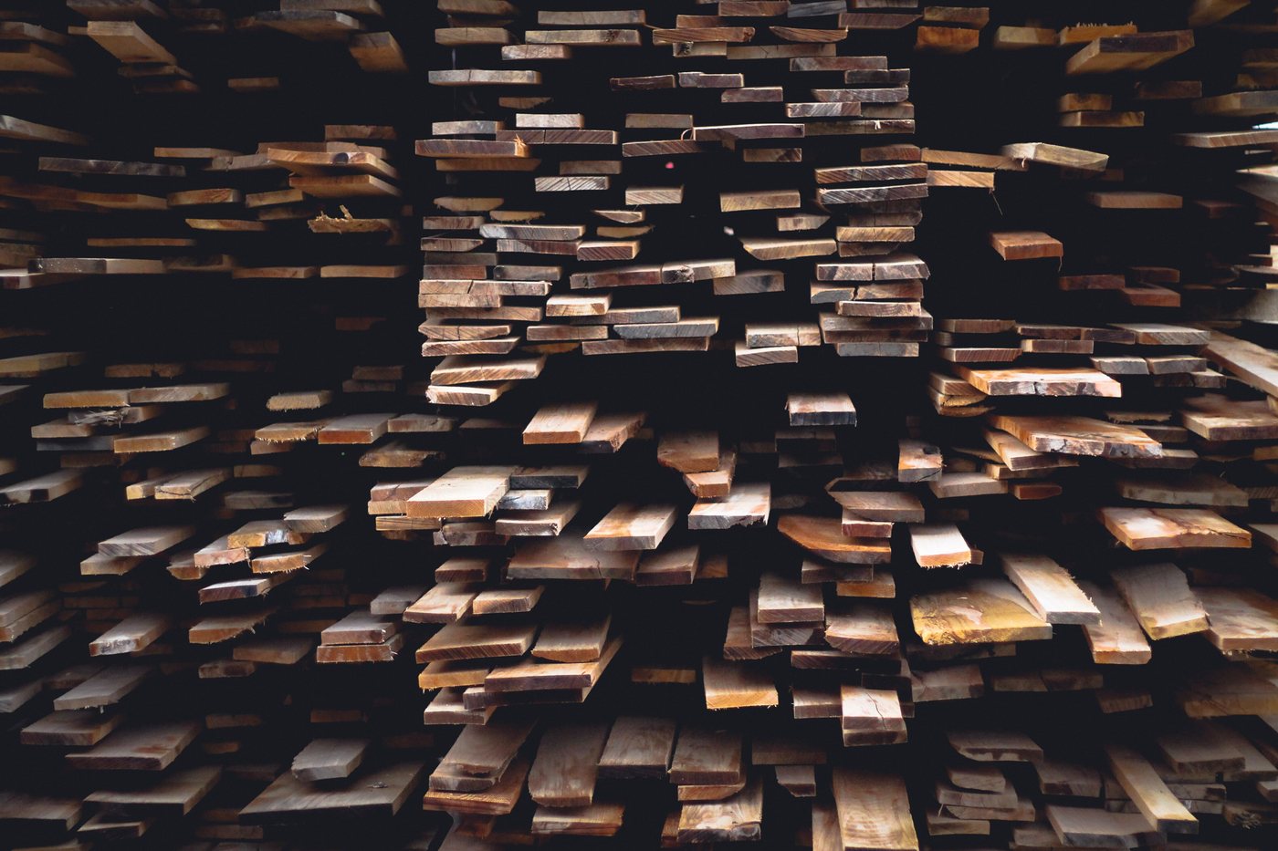The ends of several hundred sawn boards stacked in a rack, seen straight on