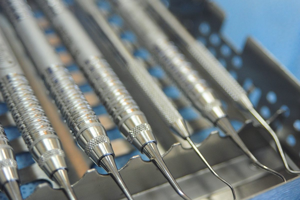 A row of dental picks and probes standing in a sterilising tray