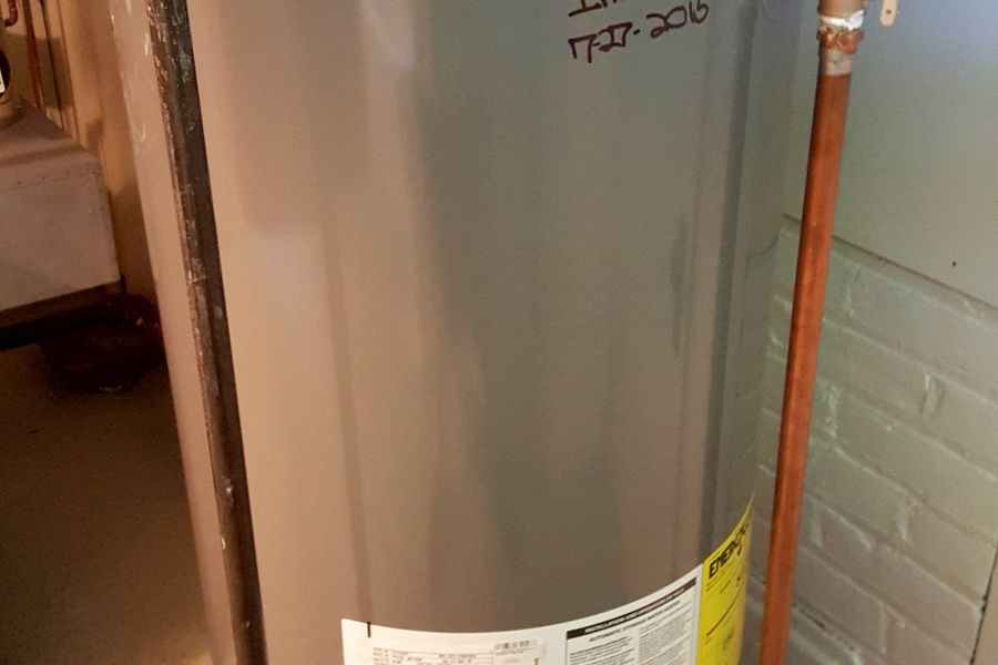 A newly installed gas water heater with copper flex connectors at the top of the tank.